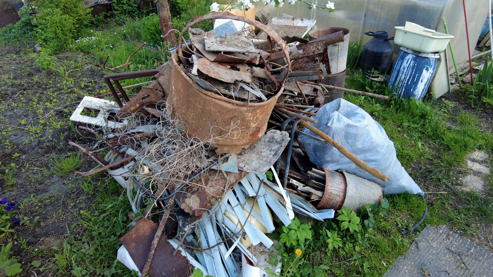 Junk pile with iron and plastic on the grass. 